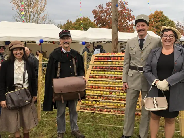 Costumés 1945 devant la pyramide de pommes